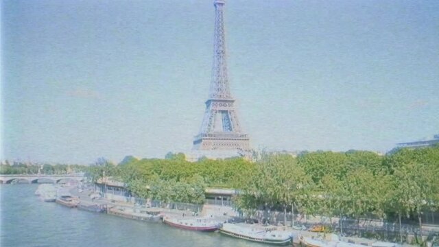 vhs vintage tape effect Aerial fast drone view over Eiffel Tower with calm Seine River tourists boats, streets green trees and homes in heart of Paris seen from above 