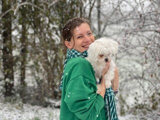Smiling women with white dog in winter