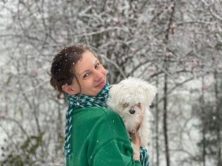Smiling women with white dog in winter