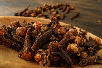 Heap of clove spice on wooden table
