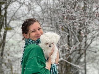 Smiling women with white dog in winter
