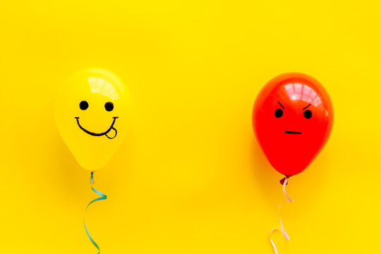 Emotions concept - happiness and anger on the colored ballons. Top view