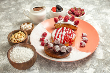 side close view of plate of sweet with berries flour tea sieve chocolate and nuts on side on marble background