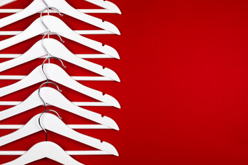 White hangers on a red background. Sales clothes concept.