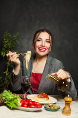 Happy beautiful woman eating italian pasta in restaurant