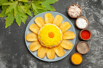 top view of salad with herbs to the right side and leaves to the left side on dark background
