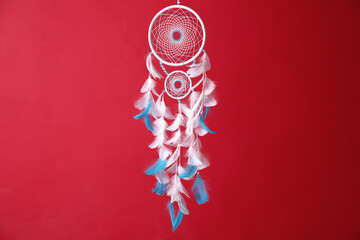 Obraz premium Beautiful dream catcher hanging on red background