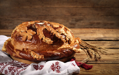 Korovai with rushnyk on wooden table. Ukrainian bread and salt welcoming tradition