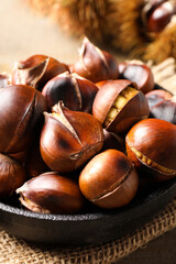 Obraz premium Tasty roasted edible chestnuts on table, closeup