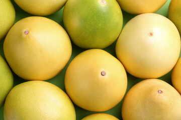 Fresh pomelo fruits on green background, flat lay