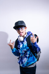 Young boy in cap and headphones, sticks out his tongue