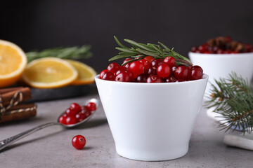 Fresh ripe cranberries and spices on grey table. Space for text
