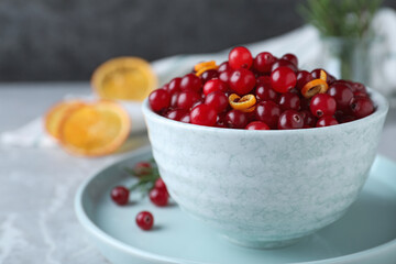 Fresh ripe cranberries on grey table, closeup. Space for text