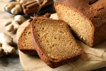 Fresh sliced gingerbread cake on wooden cutting board, closeup