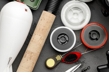 Fishing tackle on dark background top view