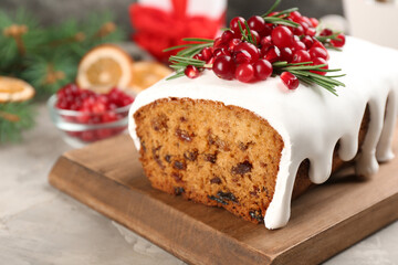 Traditional classic Christmas cake decorated with cranberries, pomegranate seeds and rosemary on table, closeup