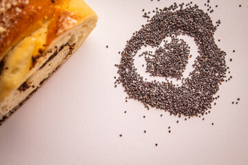 A handful of poppies in the form of a heart near the poppy roll on a white background 