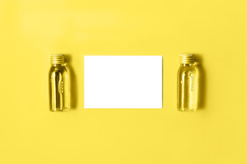 Flat lay of two small mockup bottles with spa cosmetic products toned in trendy yellow and isolated...