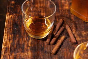 One glass of whisky and cigar on wooden table