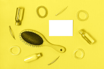 Fototapeta na wymiar Flat lay of hair care products, styling items toned in trendy yellow color and isolated white card. Women beauty and beauty salon cosmetics concept. Color 2021 concept.