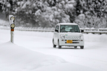 Fototapeta premium 大雪の中を走る自動車（豪雪地帯の冬）