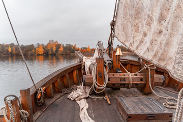 Wooden old ship in vintage style with all sails set in misty lake.