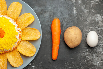 top close view of salad with carrot potato and egg on dark background