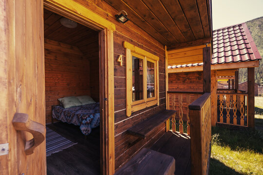 Simple bedroom interior in mountain summer resort. Wooden walls and furniture, rustic design