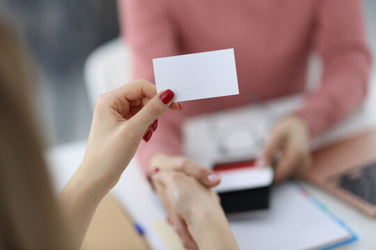 Female hands are holding white business card
