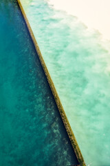 High angle view of the emerald blue waters of the Rhone river and the yellowish silty waters of the Arve river blending at their confluence called the Junction in Geneva, Switzerland.