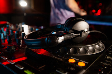DJ has break in music session. Close up photo of disk jockey console or turntables with headphones...