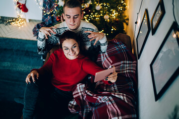 Fototapeta na wymiar Enjoyable Christmas couple taking selfie