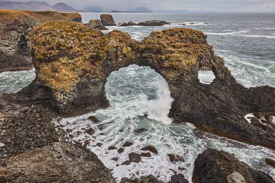 A rock arch among basalt lava cliffs at Arnastapi, on the coast of the Snaefellsnes peninsula, west Iceland