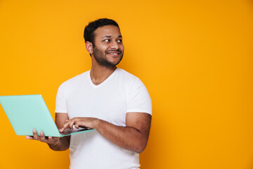 Asian happy unshaven man smiling and working with laptop