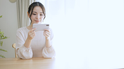 スマートフォンで動画を観る若い女性