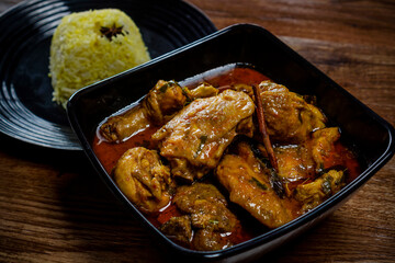 Chicken Rendang served with Nasi Minyak or butter rice isolated on wooden background.