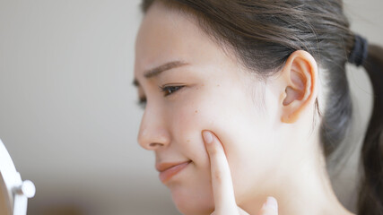 若い女性がスキンケアをしている © aijiro