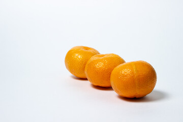 Tangerines on a white background. Citrus fruit. Three tangerines lie next to each other