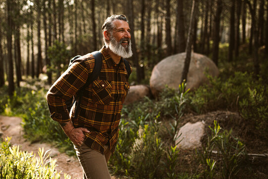 Happy Senior man smiling on hike in forest