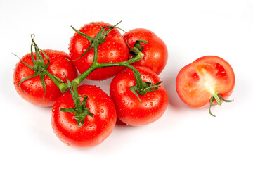 whole and slices of red tomatoes on a white background