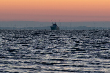 Fototapeta premium a ship on the sea at sunrise