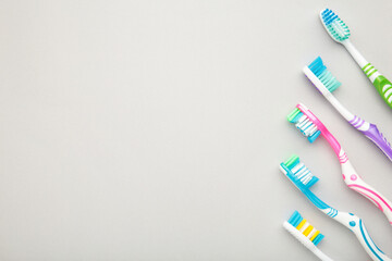 Toothbrushes on grey background with copy space.