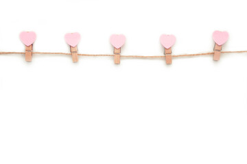 Pink hearts on rope with clothespins, isolated on a white background. Top 2021.