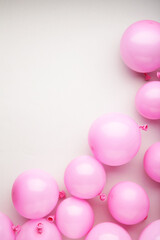 Pink pastel party balloons on grey background with copy space for text.
