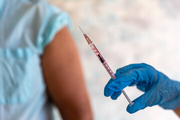 Nurse holding a syringe for the injection giving patient vaccine