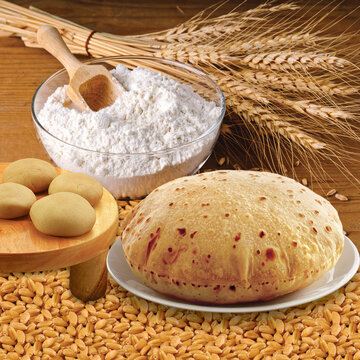 Wheat flour, Chapati, Roti, Bunch of wheat ears, dried grains, flour in terracota bowl. Cereals harvesting, bakery products.