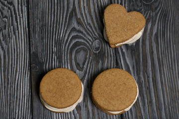 Gingerbread cookie with marshmallows. Zephyr sandwich on black pine boards.