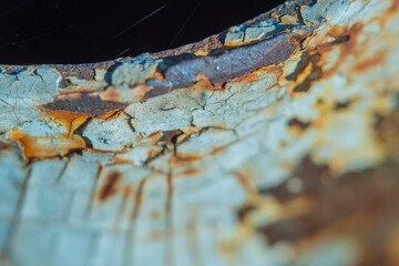 Close-up of a part of an old metal structure. Blurred background in soft focus with rusty metal surface with peeling paint.