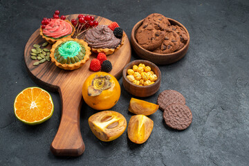 front view delicious cakes with biscuits and fruits on dark background sweet pie cake