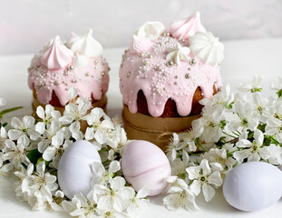 Easter still life. Baked Easter cakes and colored eggs with cherry blossoms. soft pastel colors. 